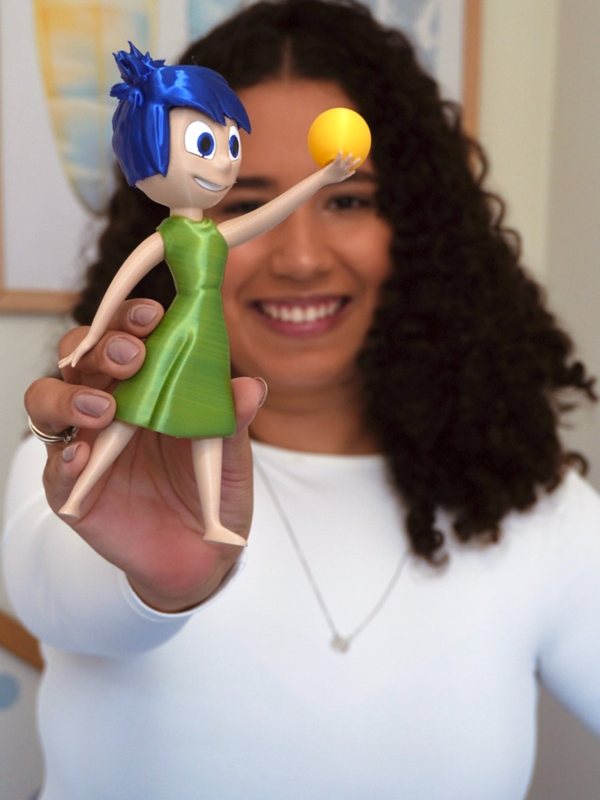 Mari mostrando um boneco da Alegria no consultório